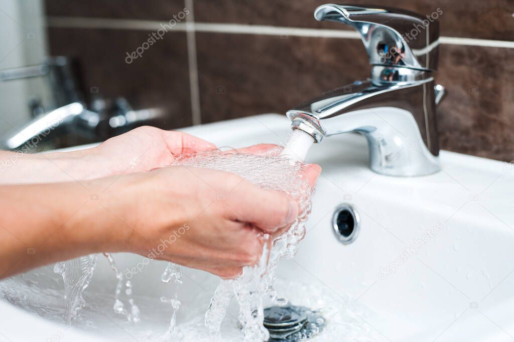 Washing hands under the water tap or faucet without soap. Hygiene concept