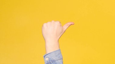 Erkek El, Baş Parmak İşareti Gösteriyor. Sarı arka plan. Boşluğu kopyala