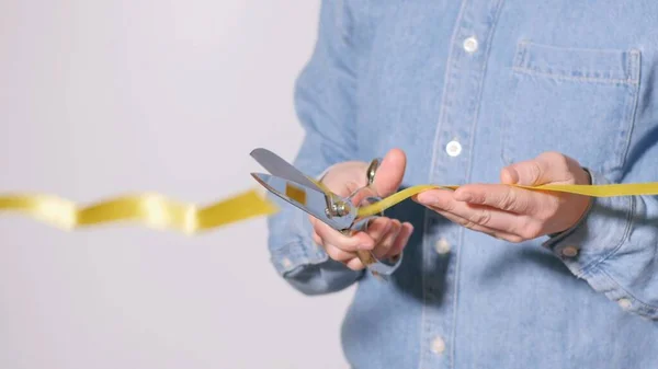 Close Mão Homem Cortando Uma Fita Amarela Com Uma Tesoura — Fotografia de Stock