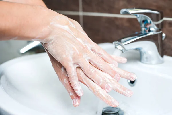 Hygiene concept. Washing hands with soap under the faucet with water