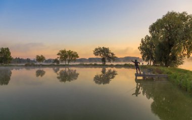 Gölde sabah sisiyle yürümek. Şafakta balık avlamak. Kiev bölgesi, Ukrayna. 20 Eylül 2020