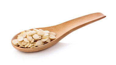 Beyaz arka planda izole edilmiş tahta kaşıktaki kabak tohumları. tam alan derinliği