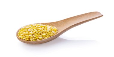 Soyulmuş mung fasulyesi tahta kaşıkla beyaz arka planda izole edilmiş.