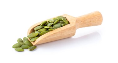 Beyaz arka planda izole edilmiş odun kepçesindeki kabak tohumları. tam alan derinliği