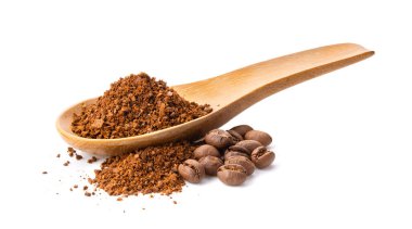 Tahta kaşıktaki kahve tozu beyaz arka planda izole edilmiş. 