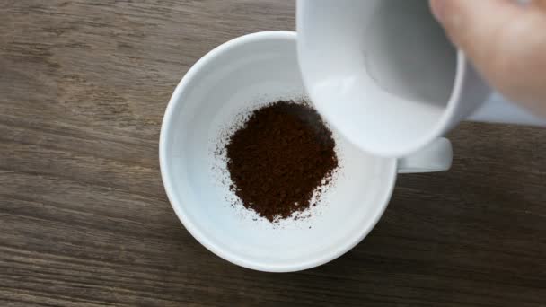  Vue du dessus de Verser de l'eau chaude dans la tasse à café sur une table en bois.