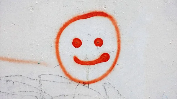 Graffiti on the ghetto wall. Smiley face on concrete background.
