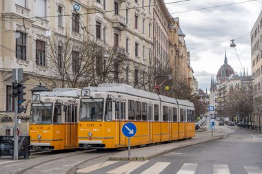 Budapeşte, Macaristan - 10 Şubat 2020: Parlamento kubbesi manzaralı ünlü sarı tramvay
