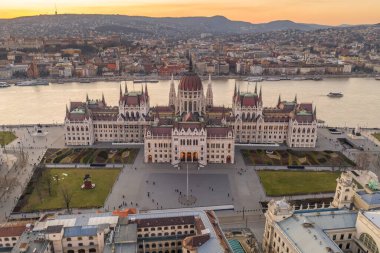 Macaristan Parlamentosu 'nun Budapeşte' nin Kossuth Meydanı 'ndaki Tuna nehri kıyısında kışın gün batımında hava aracı görüntüsü.