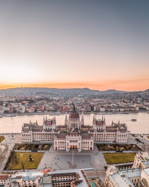 Macaristan Parlamentosu 'nun Budapeşte' nin Kossuth Meydanı 'ndaki Tuna nehri kıyısında kışın gün batımında hava aracı görüntüsü.