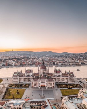 Macaristan Parlamentosu 'nun Budapeşte' nin Kossuth Meydanı 'ndaki Tuna nehri kıyısında kışın gün batımında hava aracı görüntüsü.