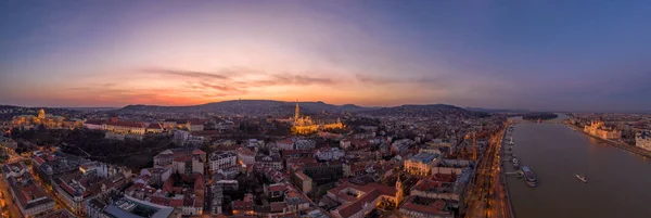 Panorama-Drohnenaufnahme der beleuchteten Matthiaskirche Budaer Burg auf dem Budaer Berg an der Donau in Budapest bei Sonnenuntergang — Stockfoto