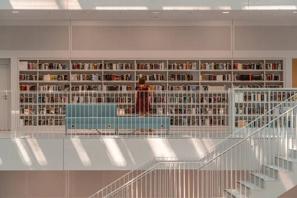 Stuttgart, Alemanha - 1 de agosto de 2020 - Mulher com livro de leitura de máscara na biblioteca Stadtbibliothek com luz solar pela manhã — Fotografia de Stock