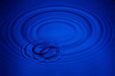 Closeup mavi dalga su halkaları makro, havuzu daire yansımalar. Arka plan iyi fikir.