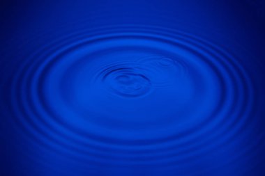 Closeup mavi dalga su halkaları makro, havuzu daire yansımalar. Arka plan iyi fikir.