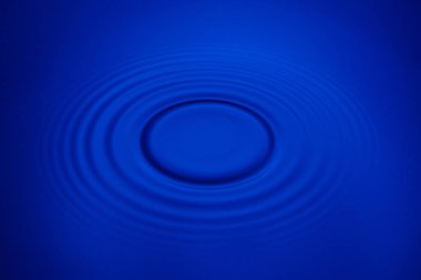 Closeup mavi dalga su halkaları makro, havuzu daire yansımalar. Arka plan iyi fikir.