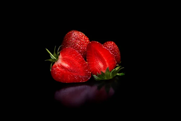 Deliciosas fresas rojas maduras naturales sobre un fondo negro —  Fotos de Stock