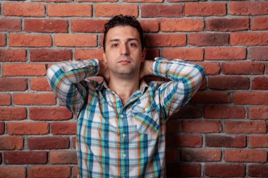 Erkek portre İtalyan, iyi arka plan yangına karşı olumlu duygular tarzı çatı katında duvar. Klechatoy gömlek, kot pantolon ve spor ayakkabı, kentsel giyim.