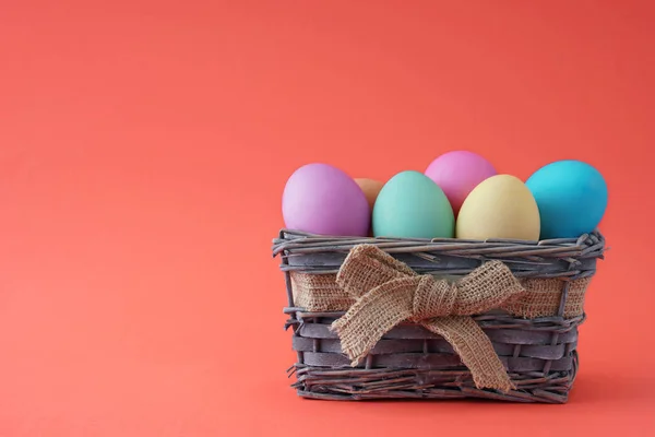 Frohe Ostern, gefärbte bunte Eier im Korb auf dem einfarbigen Hintergrund. — Stockfoto