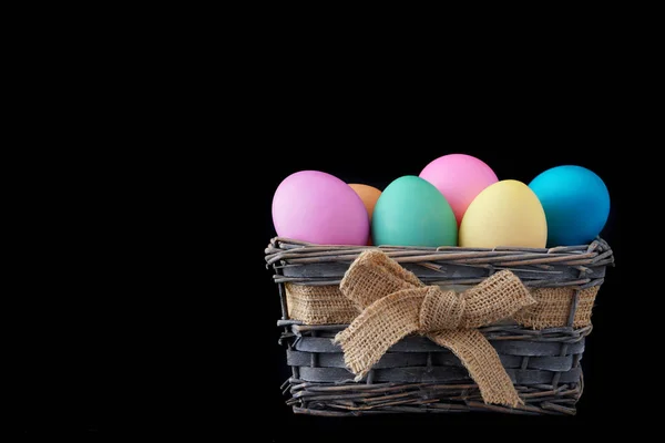 Frohe Ostern, gefärbte bunte Eier im Korb auf dem einfarbigen Hintergrund. — Stockfoto