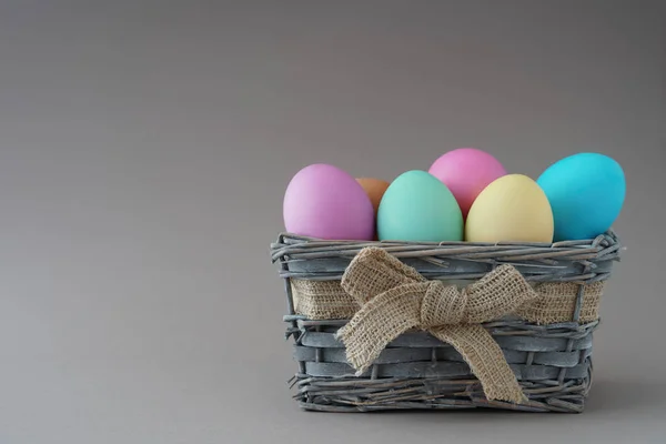 Frohe Ostern, gefärbte bunte Eier im Korb auf dem einfarbigen Hintergrund. — Stockfoto