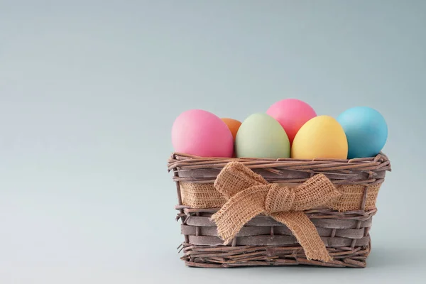 Frohe Ostern, gefärbte bunte Eier im Korb auf dem einfarbigen Hintergrund. — Stockfoto
