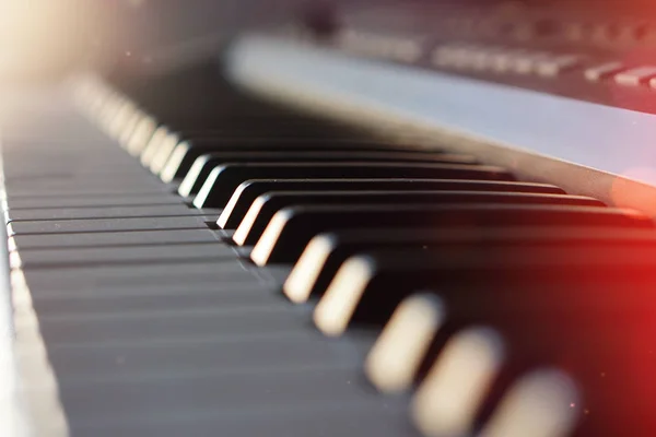 Teclado de piano sintetizador electrónico en los rayos del sol macro . — Foto de Stock