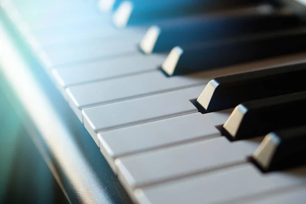 Teclado de piano sintetizador electrónico en los rayos del sol macro . — Foto de Stock