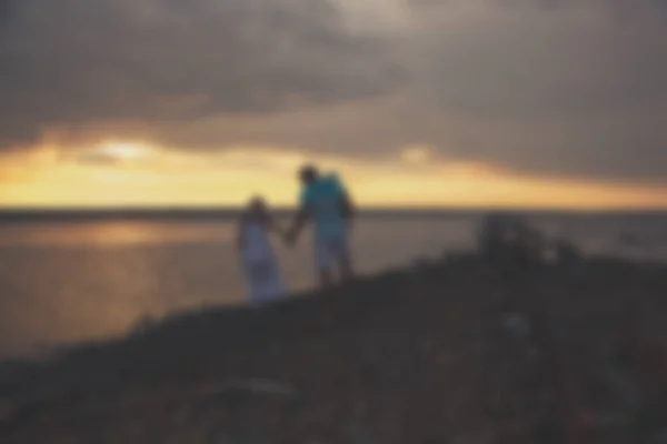 Wazig - jonge gezin vader moeder en dochter bij zonsondergang op het meer. — Stockfoto
