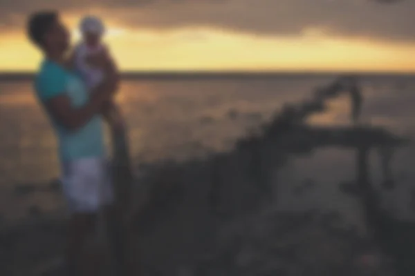 Sfocato - Giovane padre e sua figlia al tramonto sul lago . — Foto Stock
