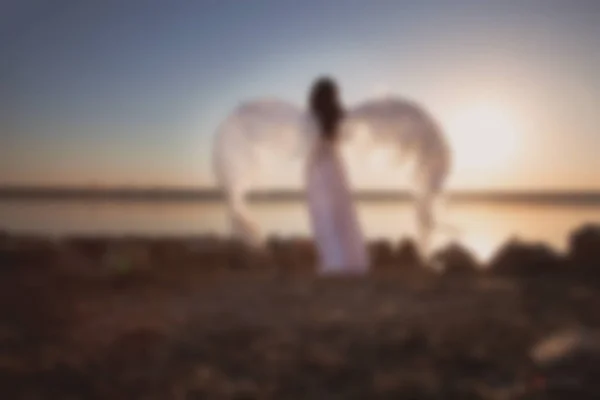 Blurry picture for background, Angel at sunset by the sea,  good idea fantasy.