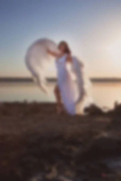 Blurry picture for background, Angel at sunset by the sea,  good idea fantasy.