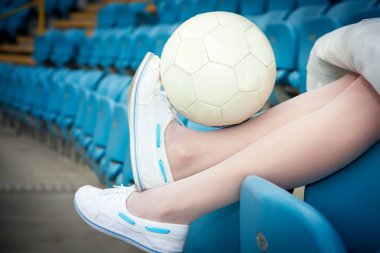 Tribünde oturan bir beyaz deri top tutan spor ayakkabı kadın bacak.