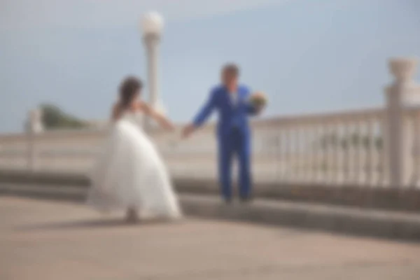 Blurred image background wedding theme on the beach, embankment young couple. — Stock Photo, Image