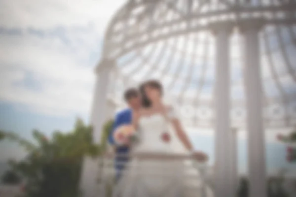 Beeld wazig achtergrondthema bruiloft op het strand, Dijk jong koppel. — Stockfoto