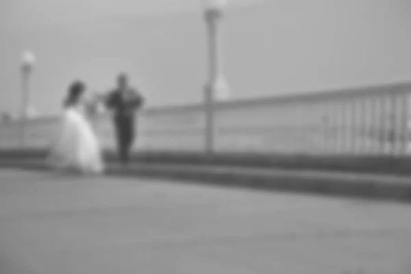 Imagen borrosa fondo boda tema en la playa, terraplén joven pareja . — Foto de Stock