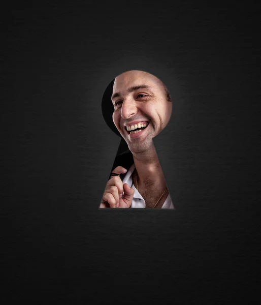 Looking through the keyhole at the guy, the emotions of joy. — Stock Photo, Image