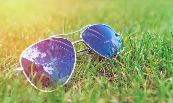 Мягкий фокус, солнечные очки на зеленой траве, летнее настроение . — стоковое фото