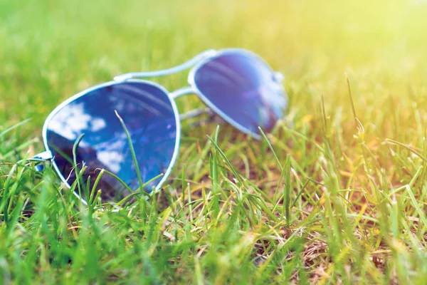 Enfoque suave, gafas de sol en la hierba verde, humor de verano . — Foto de Stock