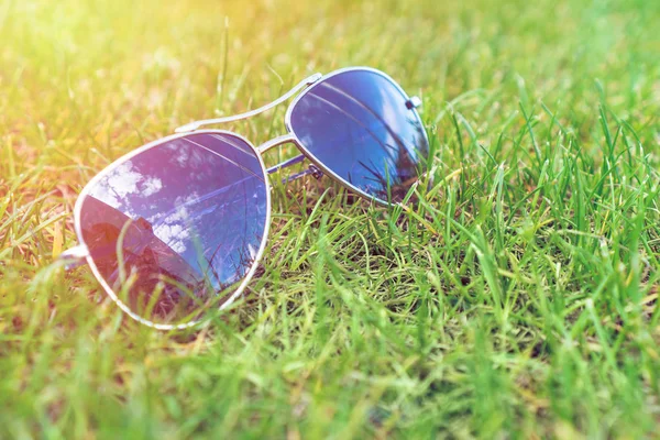 Enfoque suave, gafas de sol en la hierba verde, humor de verano . — Foto de Stock