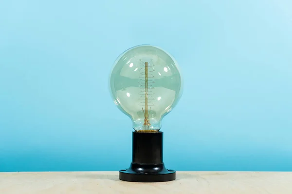 Edison elektrisk lampa, på en blå bakgrund. Kreativ idé. — Stockfoto