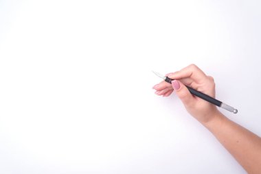 Nazik bir manikür ile moda kadının elini bir araç tutar. Güvenli iş, bir yazıt için yer. Yukarıdan görüntüleyin. Beyaz arka plan, zıt gölge.