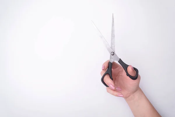 La mano de la mujer de moda con una manicura suave sostiene una herramienta. Trabajo seguro, lugar para una inscripción. Vista desde arriba. Fondo blanco, sombra contrastante . —  Fotos de Stock