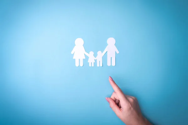 Female tender hands with a family symbol cut out of white paper. Protecting the rights of people and sexual minorities. Love for the children of the world on earth, a clean ecology. View from above. — Stock Photo, Image