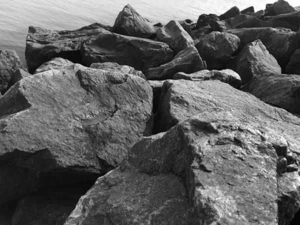 Gránitkövek a tengerparton. Fekete-fehér fénykép. Kontrasztos, jó textúra. Természeti minta. — Stock Fotó