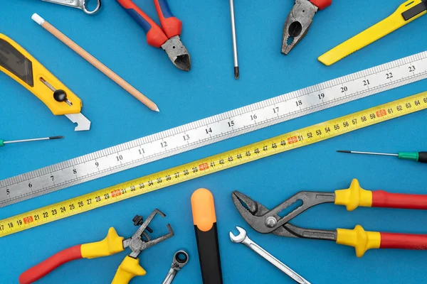 Various tools for repair, a tool kit for the home, on a blue background, safe work for construction.