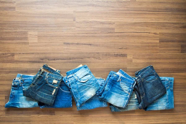 Jeans Empilés Sur Fond Bois Vue Haut Avec Espace Travail — Photo