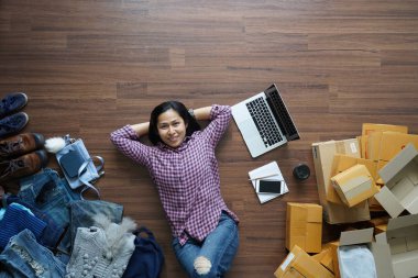 Üstten görünüm küçük işletme sahibi kadın posta parsel ile ahşap yerde yatarken online satış, e-ticaret, fikir kavramı nakliye