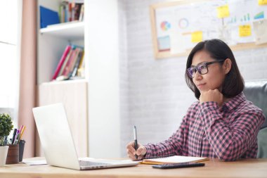Asyalı kadın yönetici yardımcısı rapor dizüstü bilgisayarla iletişim bilgi okumada ve dikkat çeken, küçük iş sahibi fikir kavramı kontrol