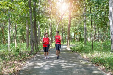 Asya kadın adam veya kişisel antrenör park, Yaşlı Bakımı egzersiz spor etkinlik kavramı koşma koşu kıdemli mutlu